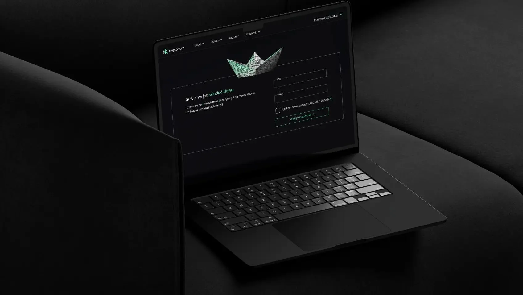 A dark laptop on a black background displays the brand’s newsletter template.
