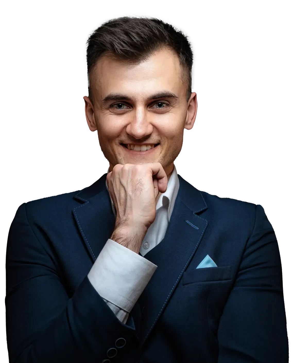Kuba w granatowej marynarce opiera dłoń o brodę i uśmiecha się szeroko.