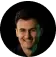 Portrait of a smiling man — Kuba Chrapek — against a dark background.