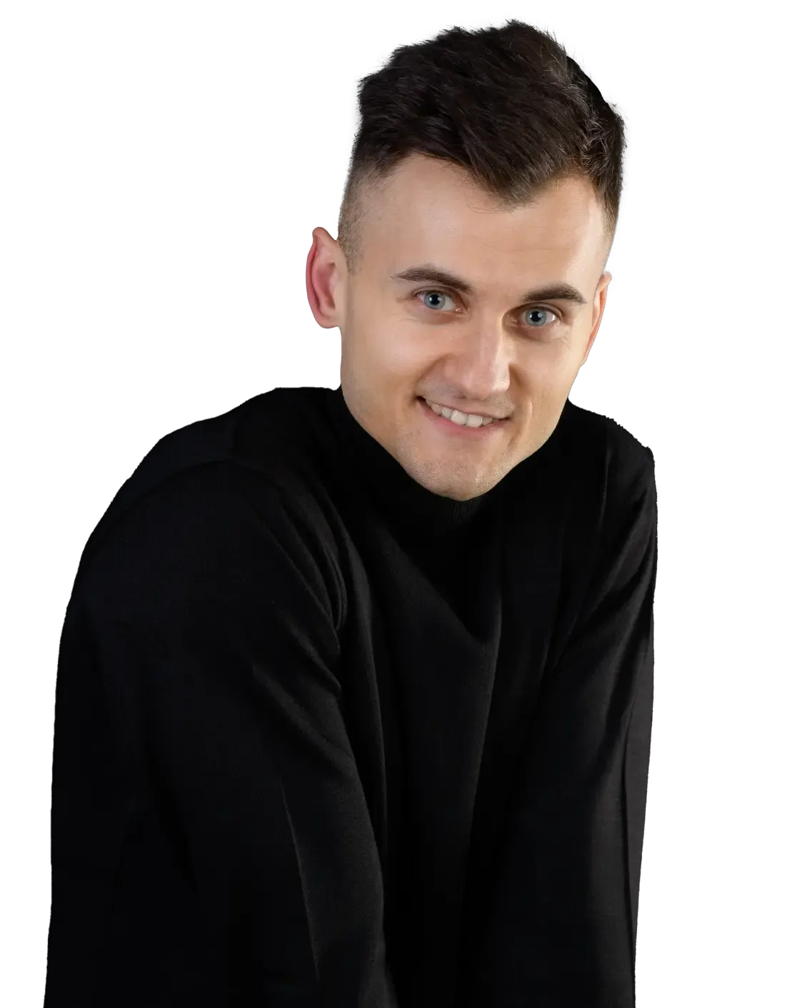 Kuba w czarnym golfie patrzy w bok z lekkim uśmiechem, całość na przezroczystym tle.